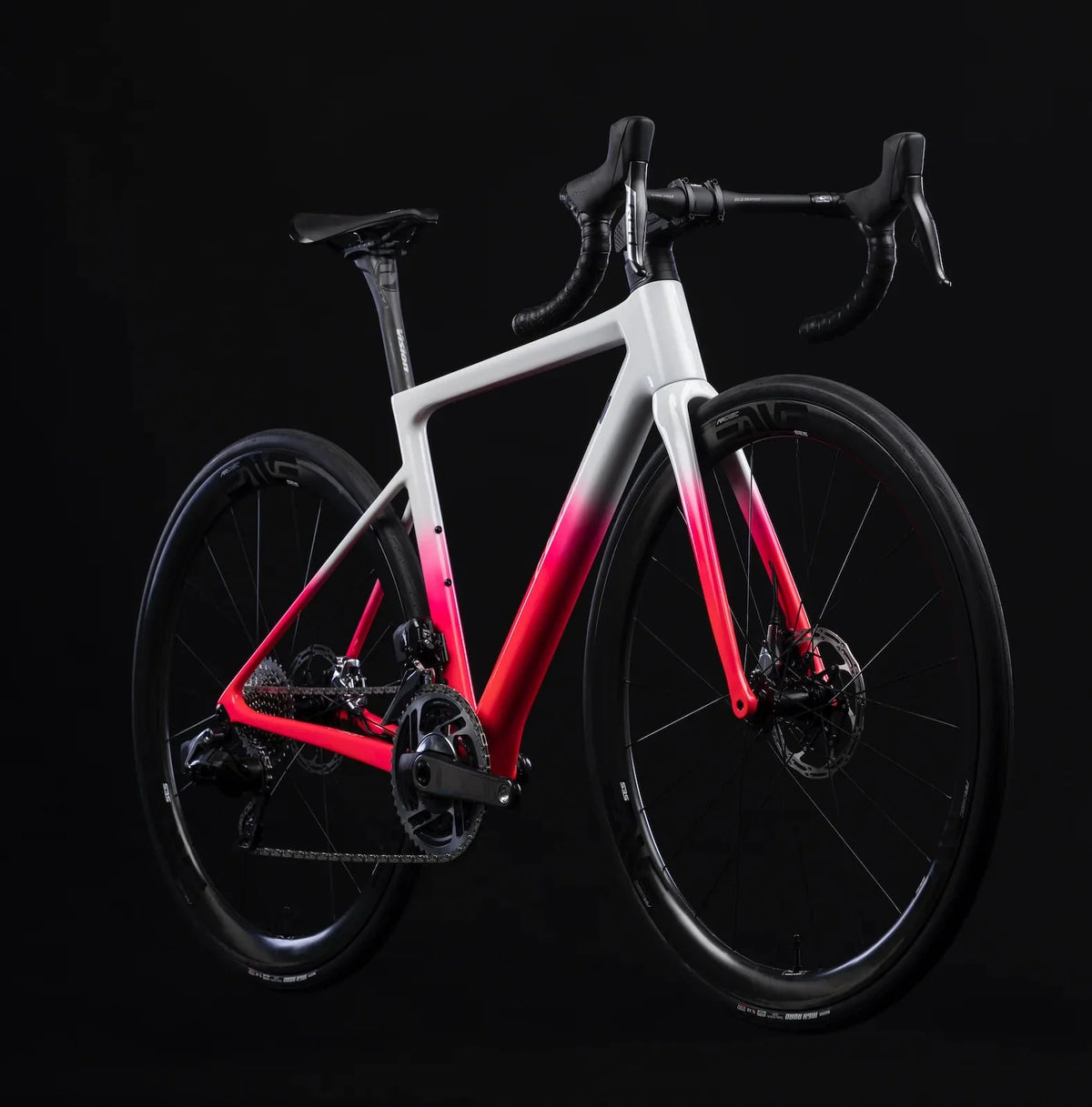 Carbon road bike with a white-to-red fade frame and drop bars, shown on a black background