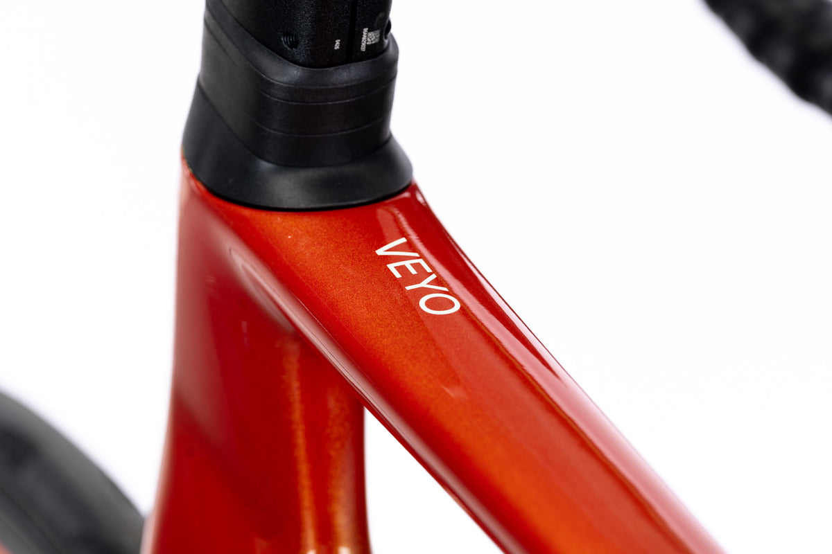 Orange-red Veyo head tube and top of the down tube with the Veyo decal