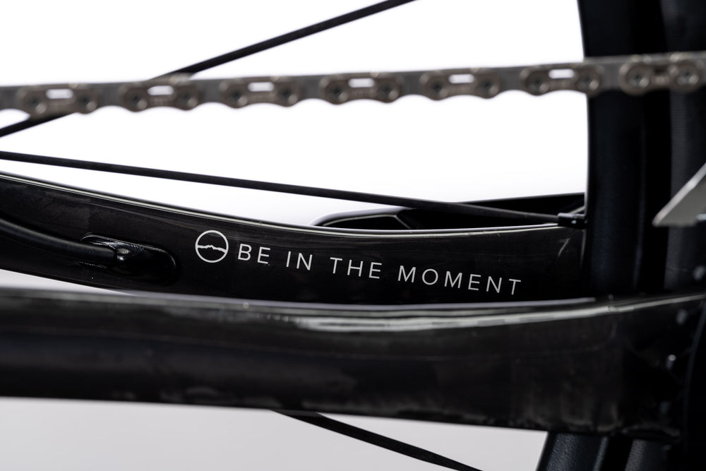 Black Veyo chainstay with Be in the Moment text and the chain above it