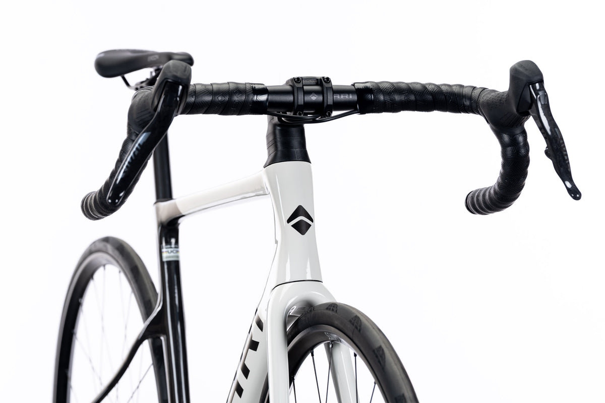 Front view of a black and white Veyo road bike with drop handlebar and brake levers
