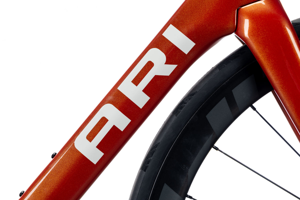 Orange Veyo down tube with a large white Ari decal above the front wheel