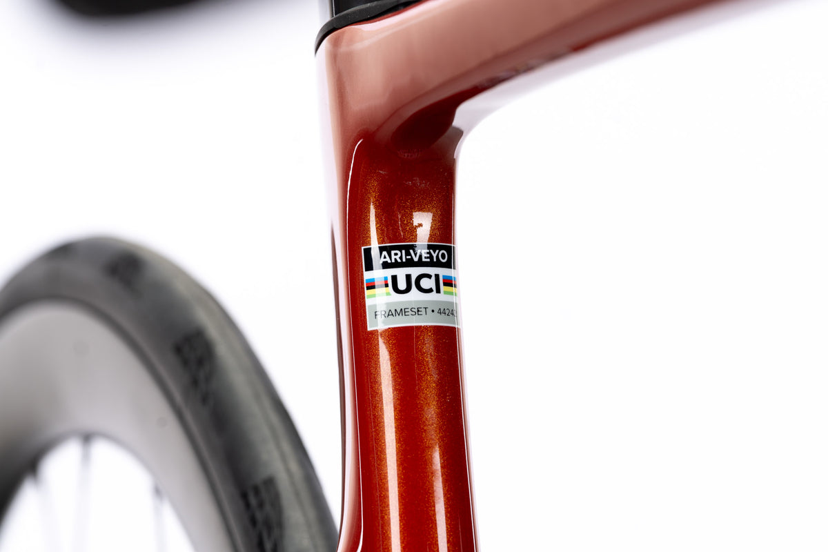 Orange Veyo seat tube with an Ari-Veyo frameset sticker and UCI label