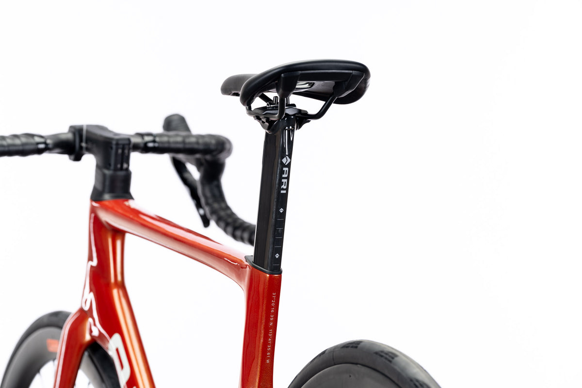 Rear view of an orange Veyo road bike with Ari seatpost, saddle and drop handlebar