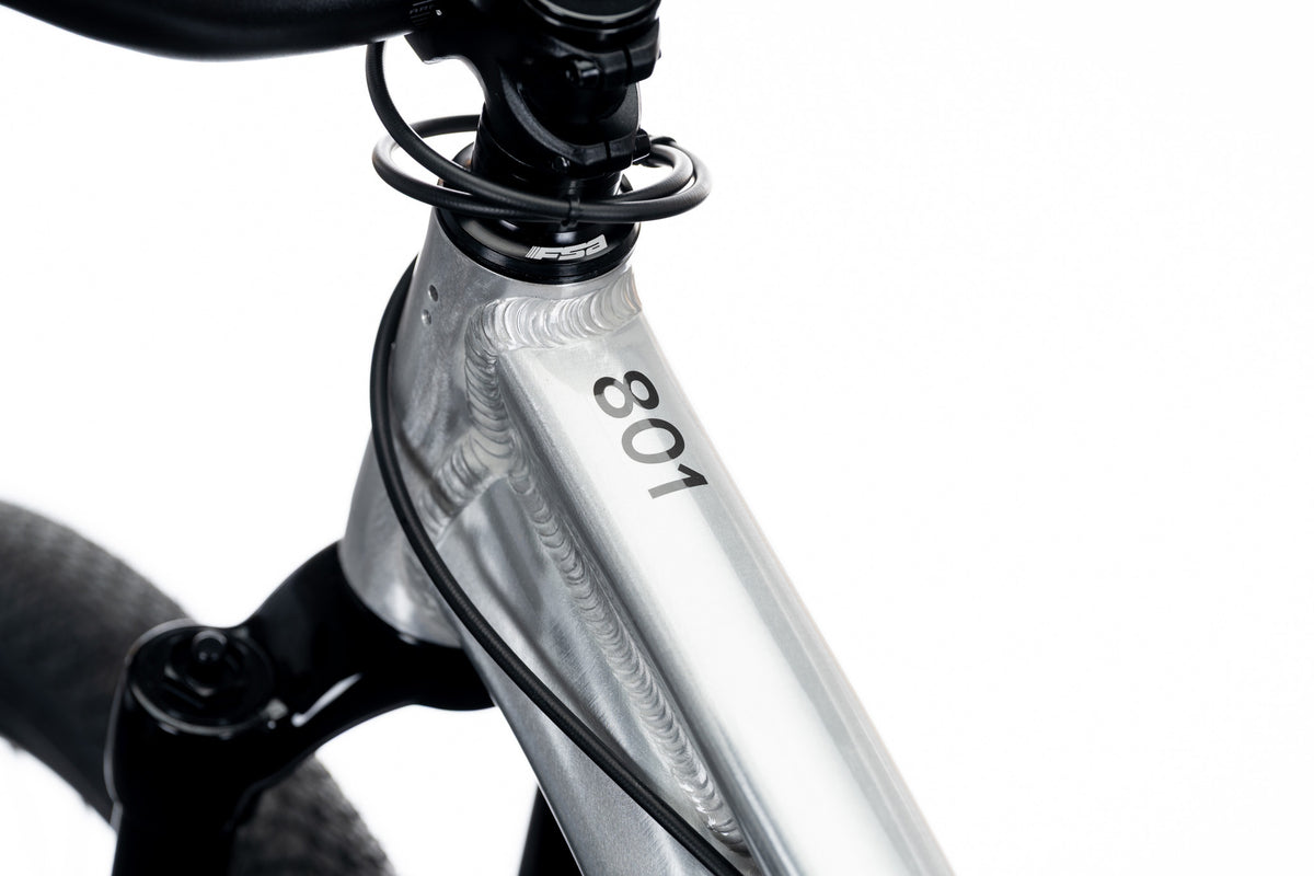 Silver 801 head tube with visible welds, the 801 decal and cables