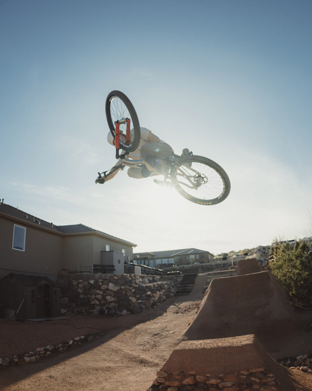 Rider inverted mid-air over a dirt jump on the 801
