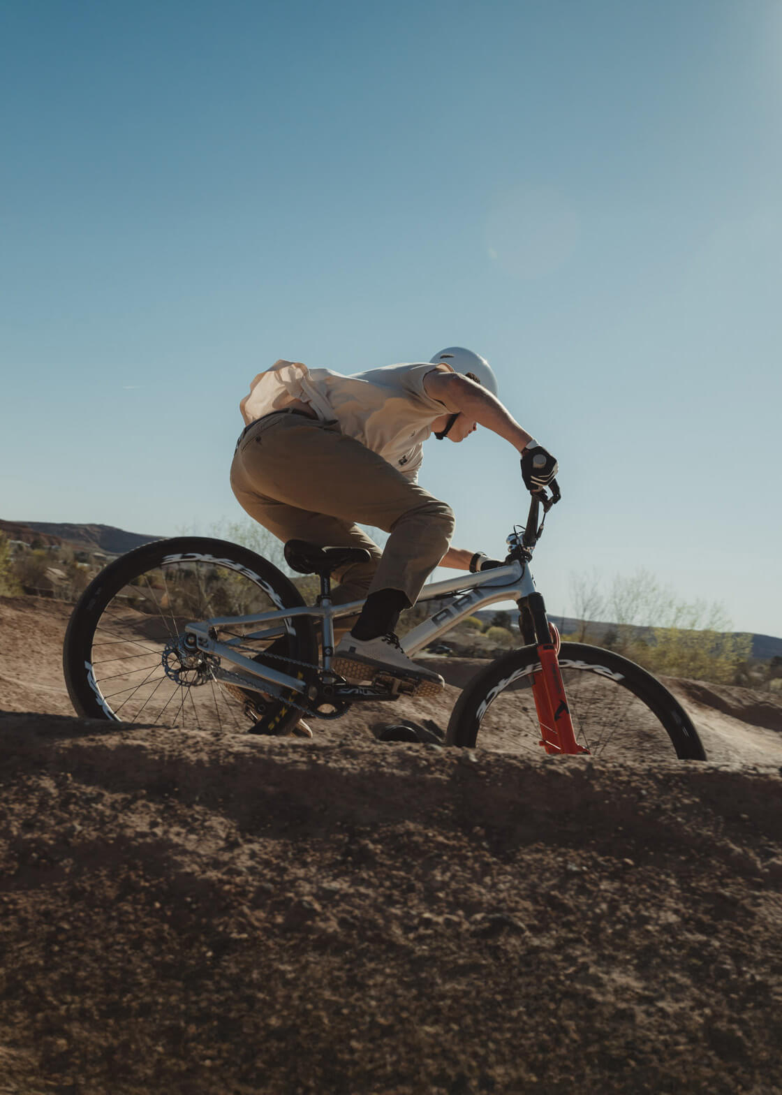 Rider carving a berm on an 801 dirt jump bike in the desert