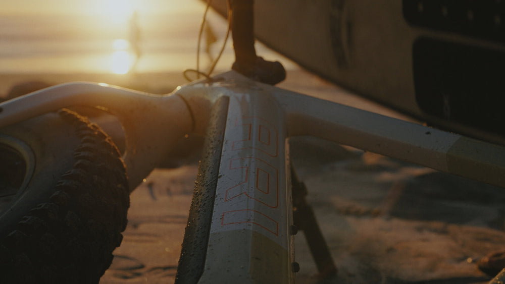Sunset close-up of a fat bike head tube and tire with the Explorer Peak decal