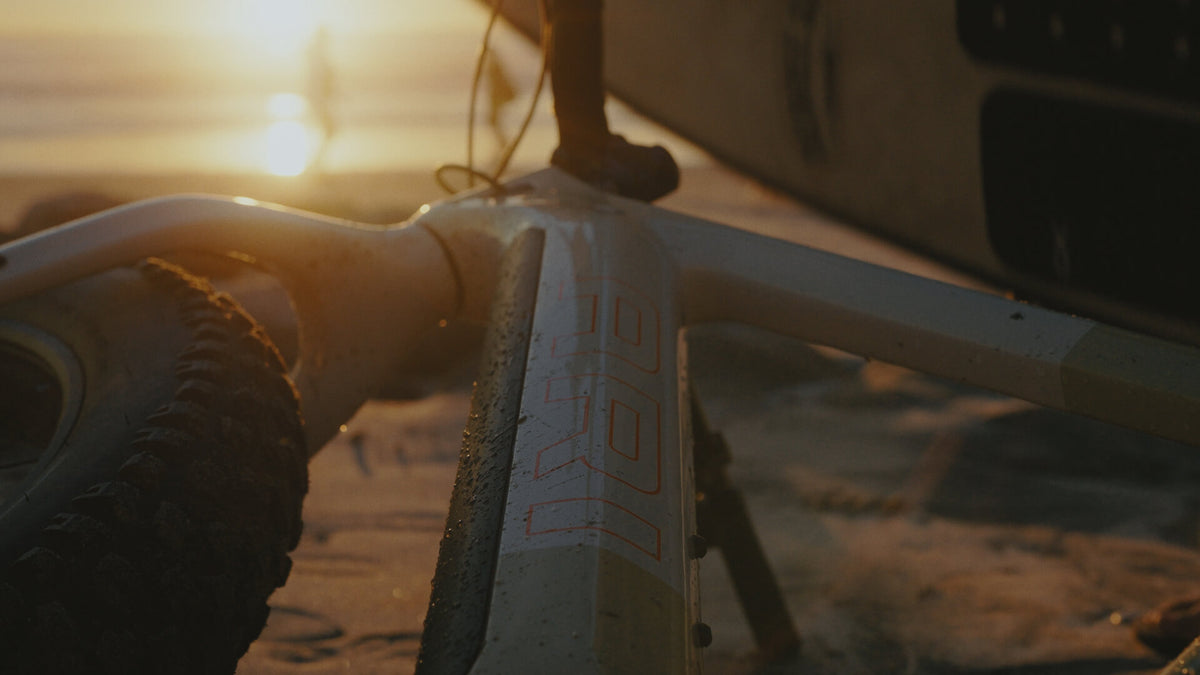 Sunset close-up of a fat bike head tube and tire with the Explorer Peak decal