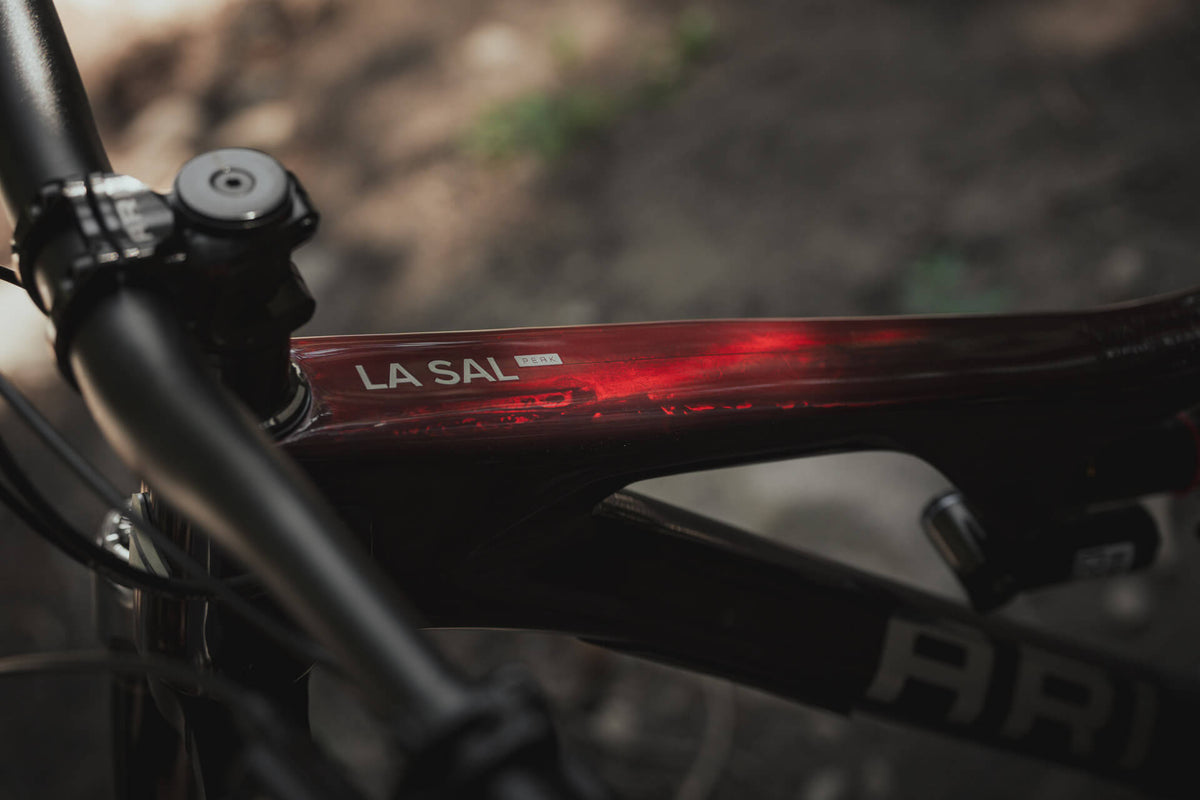 Close-up of the La Sal decal on a dark red metallic top tube near the stem
