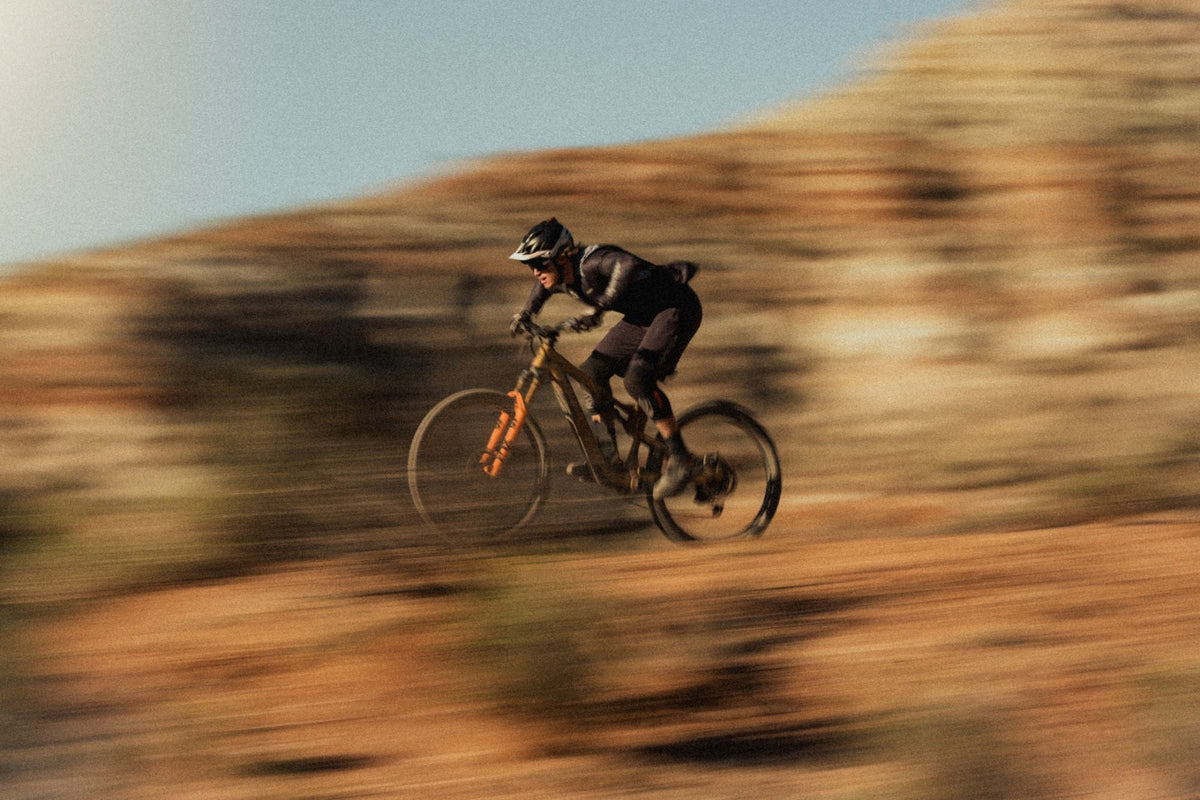 Rider speeding along a red-rock trail on the Nebo Peak, motion-blurred background