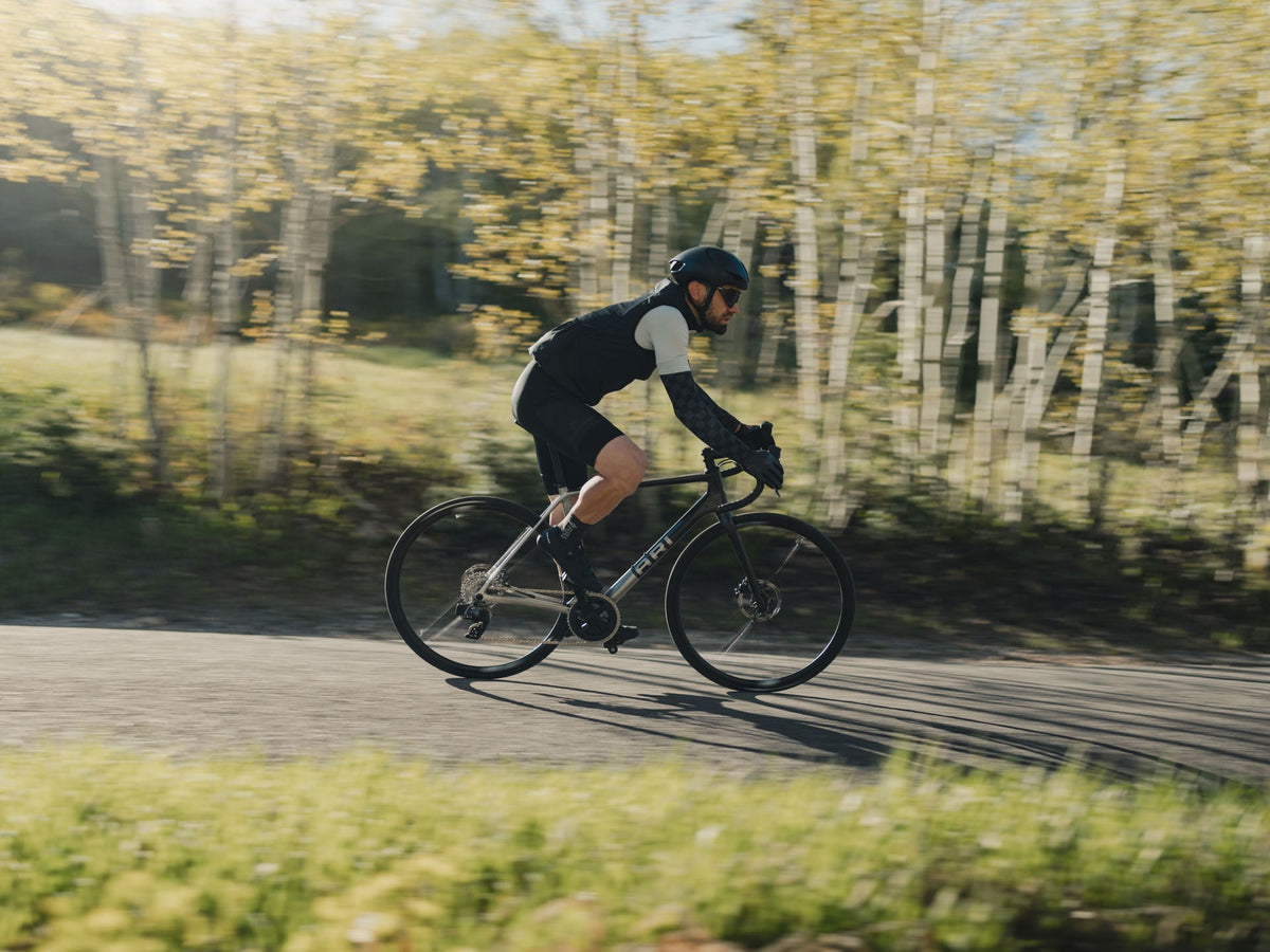 Rider on a silver Suncrest passing aspens, panned with motion blur