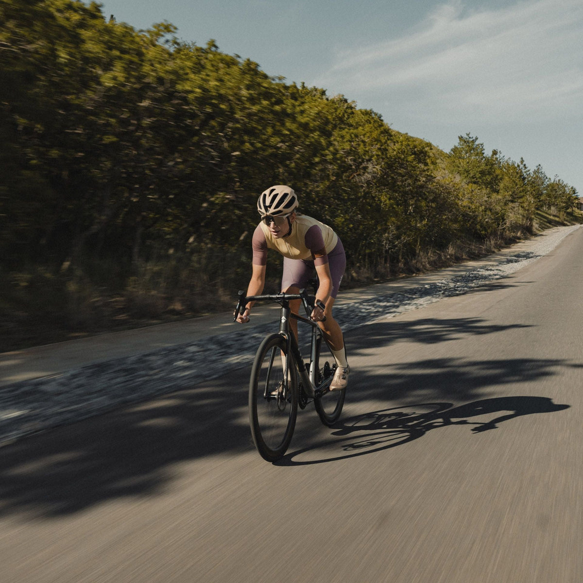 Rider on a dark Suncrest descending with a long shadow