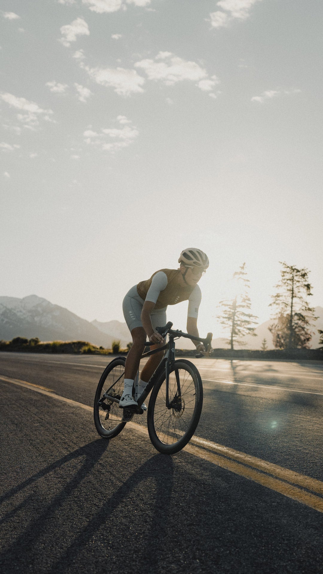 Rider on the Suncrest backlit at sunset with mountains behind