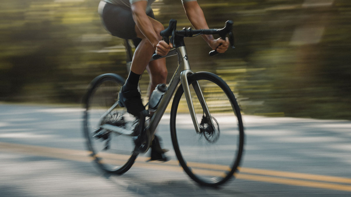 Road cyclist riding in motion blur on a yellow-lined road